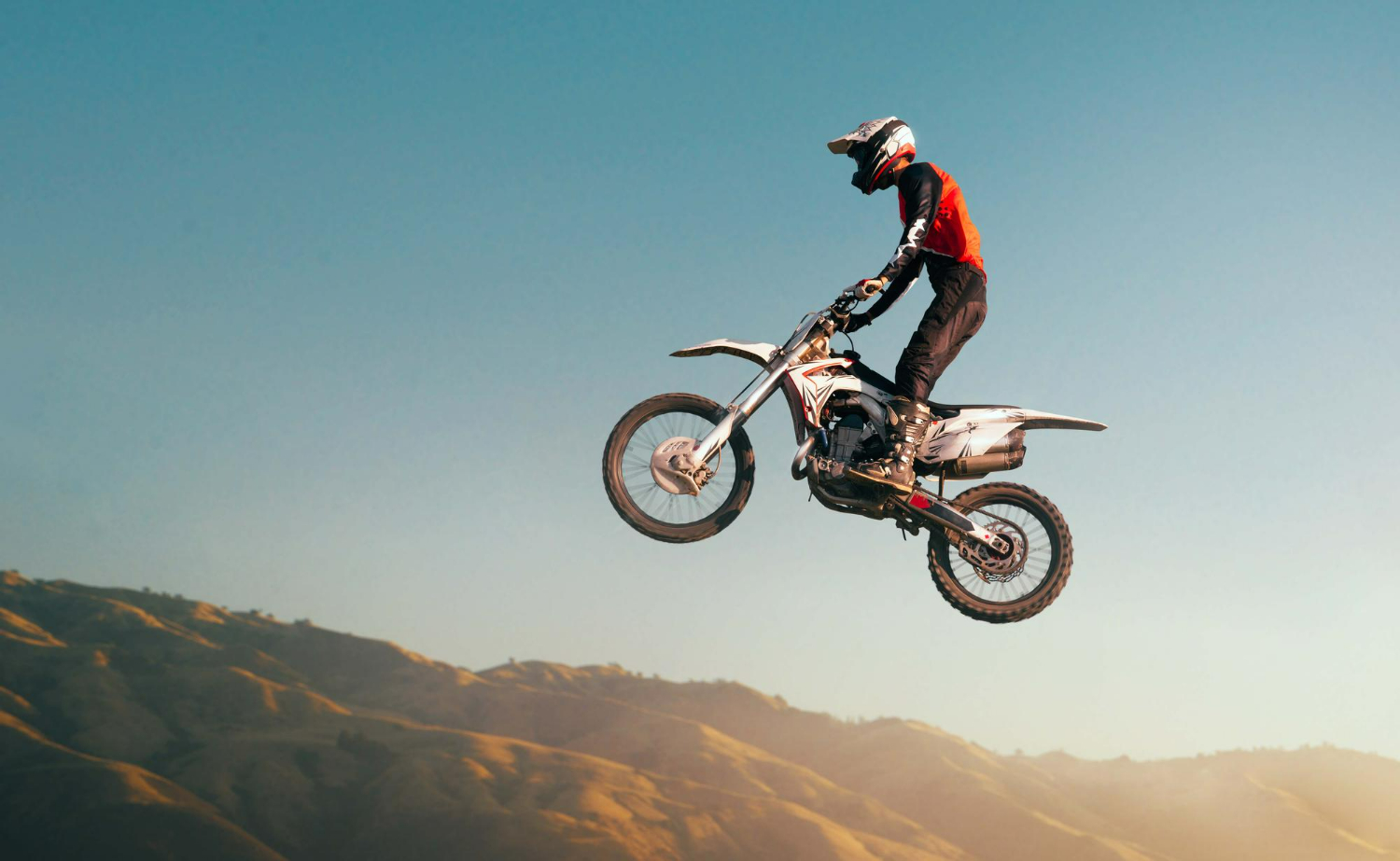 Imagem ilustrativa sobre o conjunto ASW mostrando um competidor de motocross usando o conjunto da marca em sua trilha.
