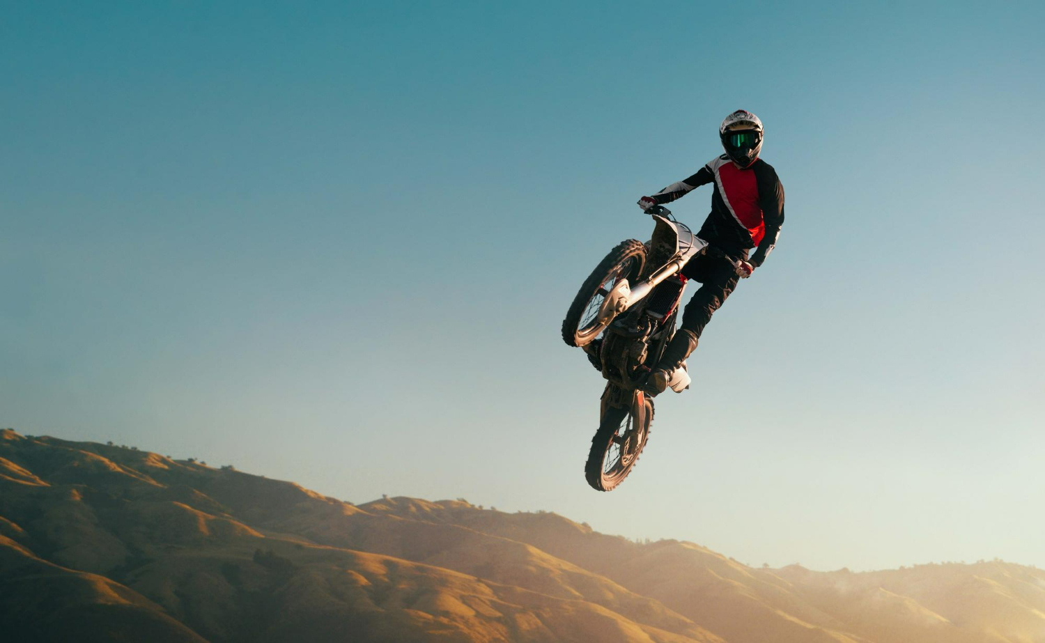 Imagem ilustrando conteúdo sobre as melhores roupas de motocross para climas quentes mostrando um competidor em sua moto.