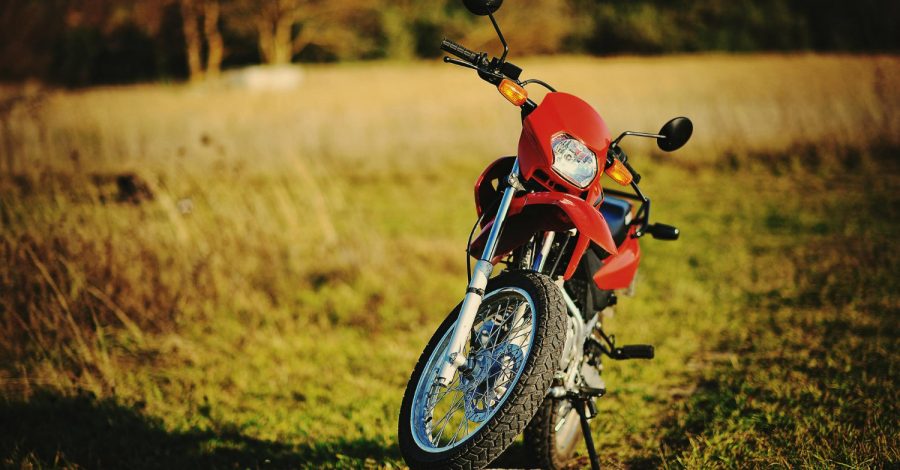 Imagem ilustrando o conteúdo sobre moto enduro mostrando uma motocicleta em meio a um campo com vegetação rasteira.