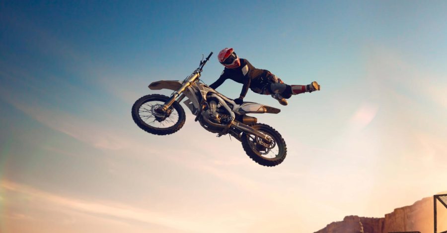 Imagem ilustrando o conteúdo sobre moto de trilha usada mostrando um competidor de motocross fazendo manobras em sua moto.