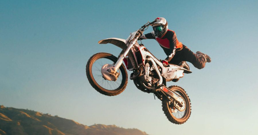 Imagem ilustrativa sobre luvas de motocross mostrando um competidor usando luvas de proteção em sua trilha.